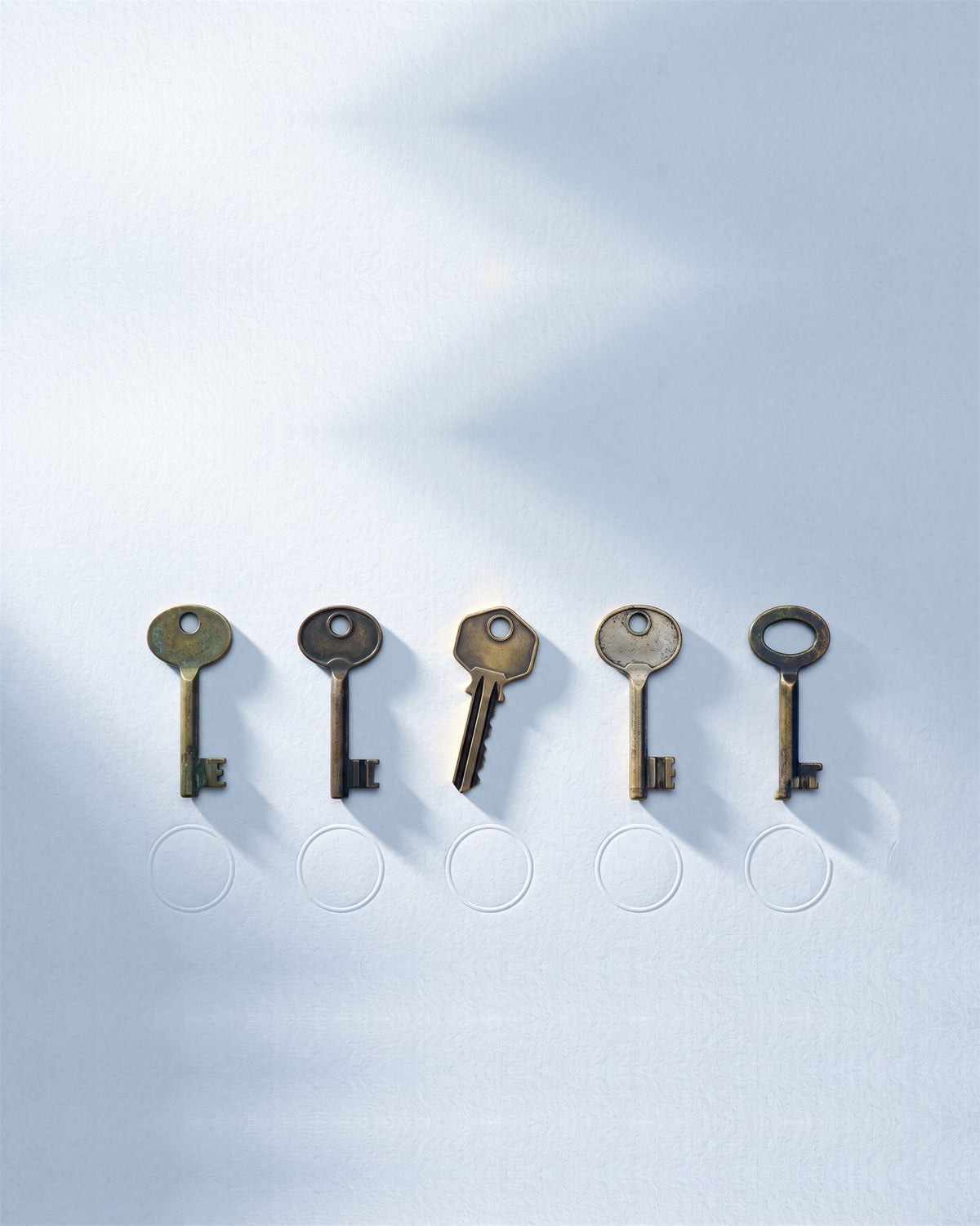 Five antique keys laid in a row above five empty rings — the Five Locks framework